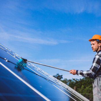 Man worker in the firld by the solar panels